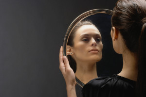 Woman checking her reflection in silver serving platter